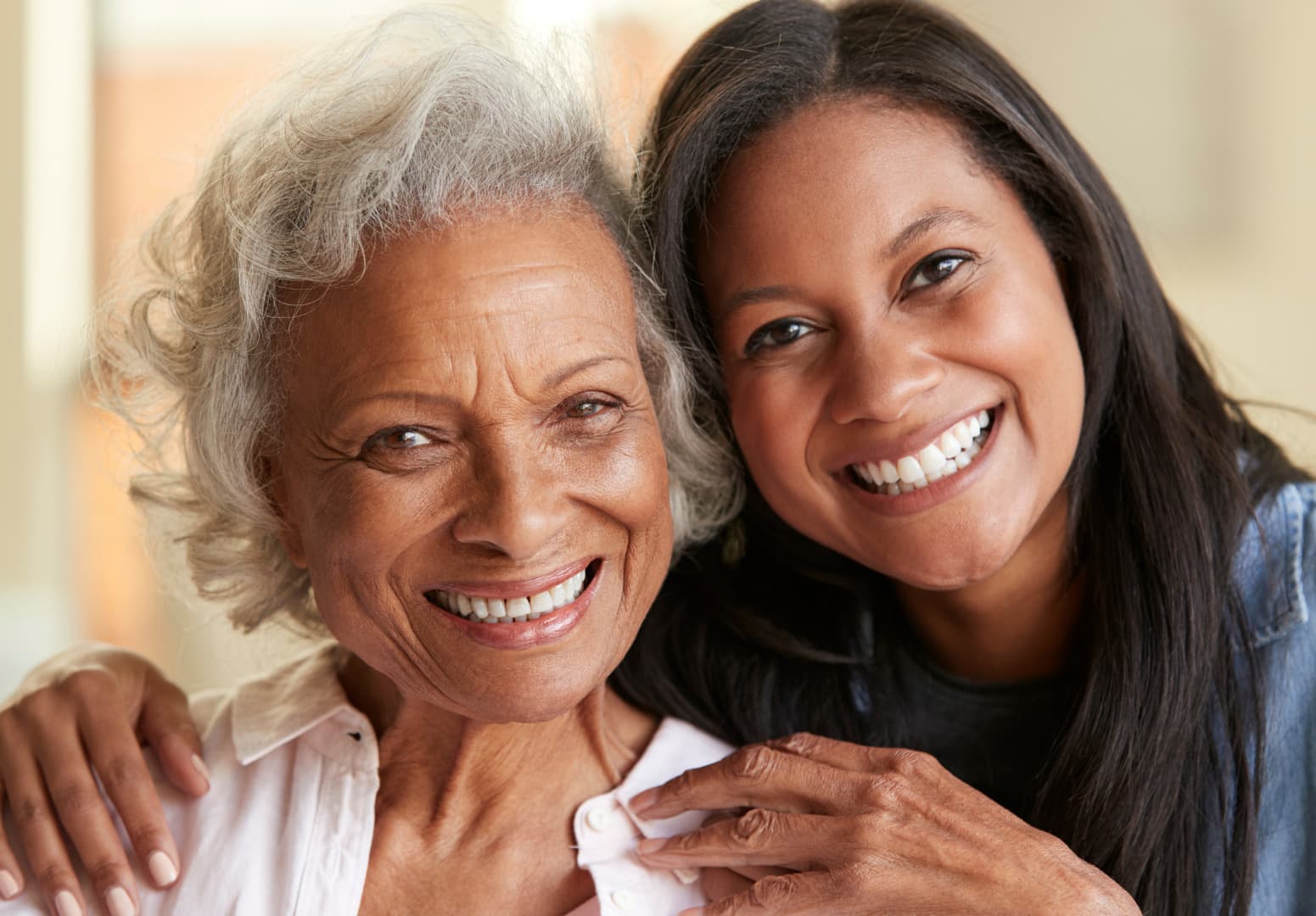 An older woman and her daughter smiling together